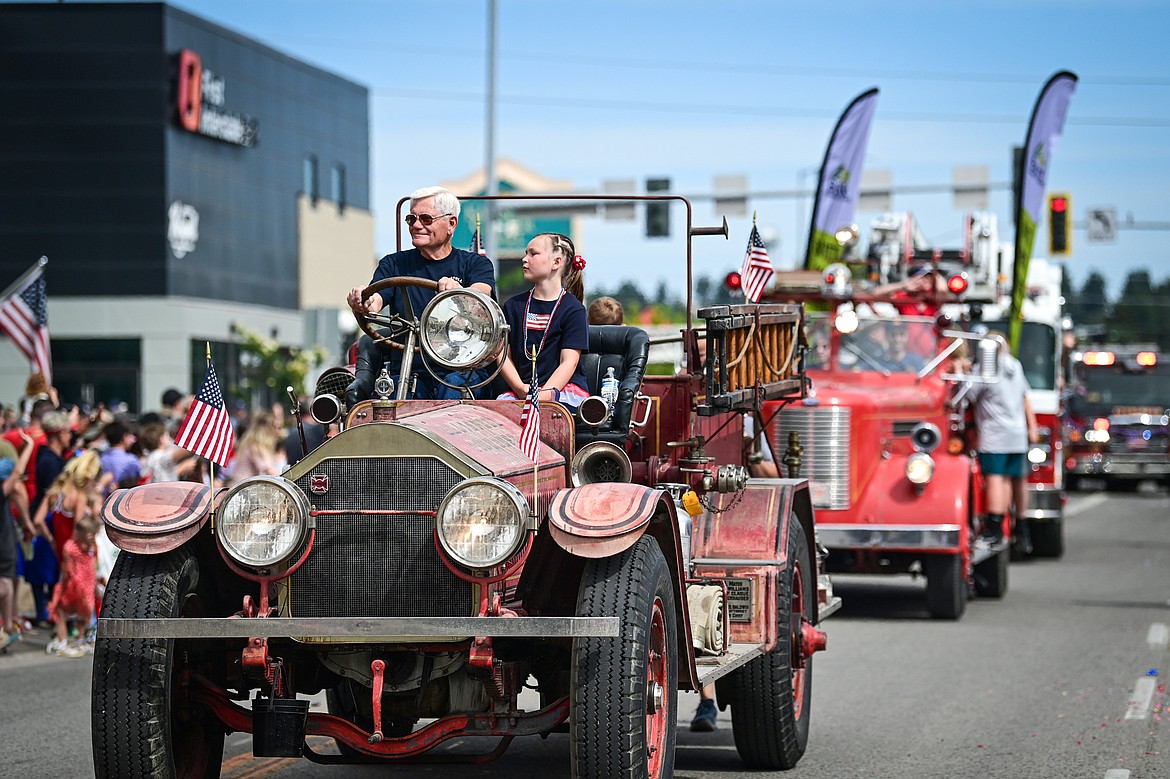 A line of old fire trucks make their way down Main Street at the Kalispell 4th of July Parade on Friday, July 4. (Casey Kreider/Daily Inter Lake)