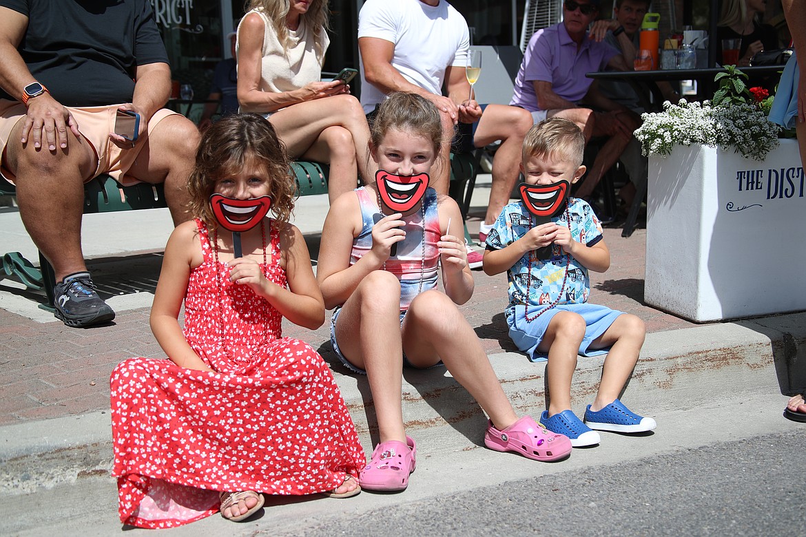 A youthful trio "smile" for the camera as they watch the Sandpoint Lions grand parade on the Fourth of July on Friday.