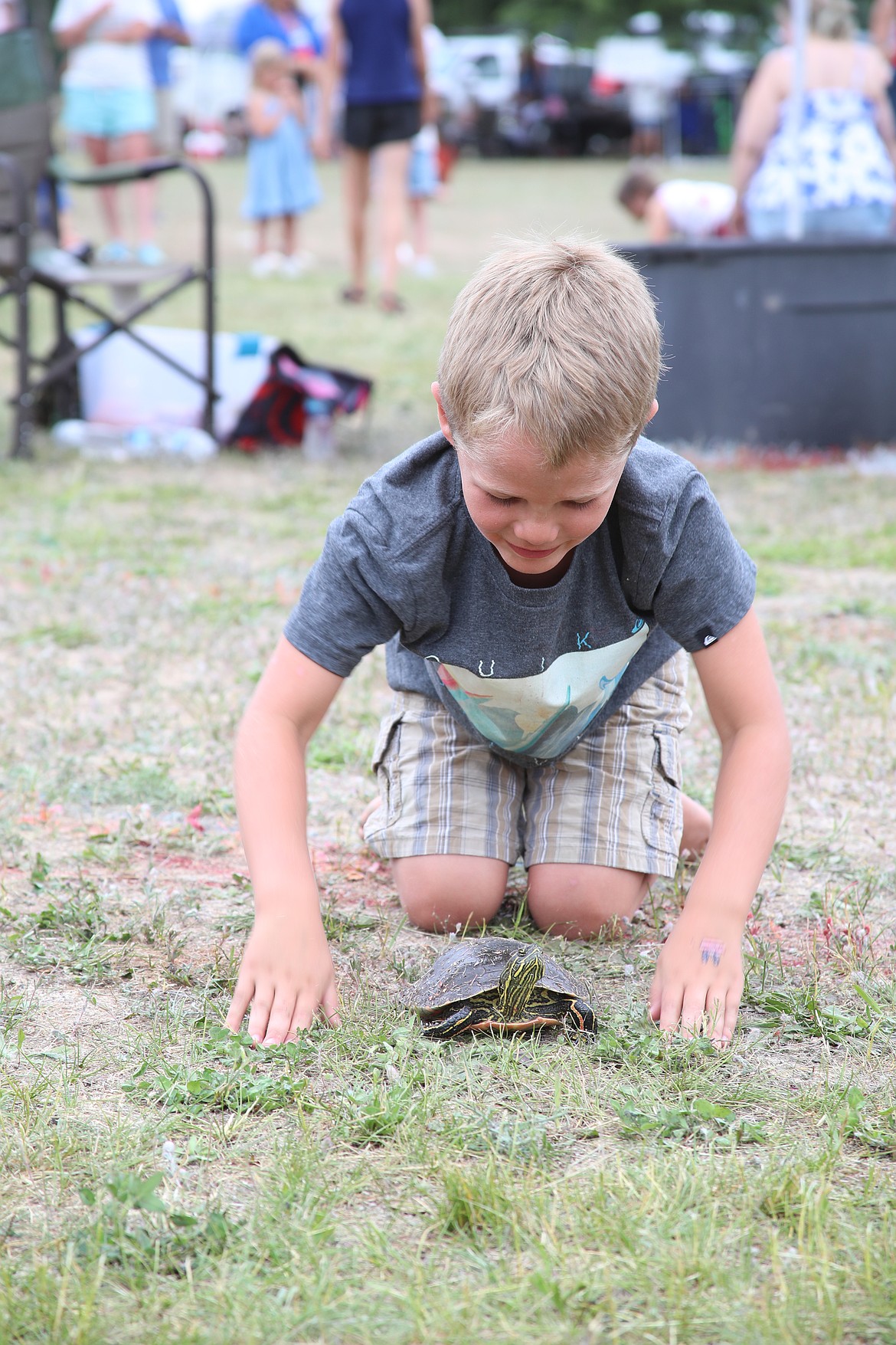 Liam Borges tries to get his turtle to move faster during a heat of this year's turtle races, held as part of the Clark Fork Fourth of July celebration.