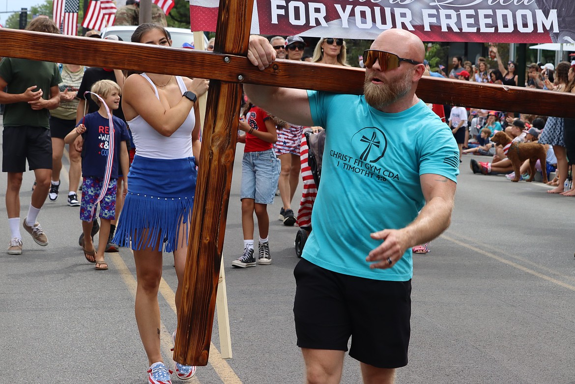 Robbie Walden carries a cross in the parade.