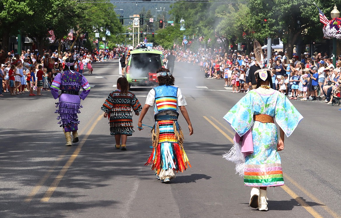 Coeur d'Alene Tribe members dance as they make their way along Sherman Avenue.