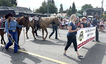 Two riderless horses for fallen firefighters walk on Sherman Avenue in the Fourth of July parade on Friday.