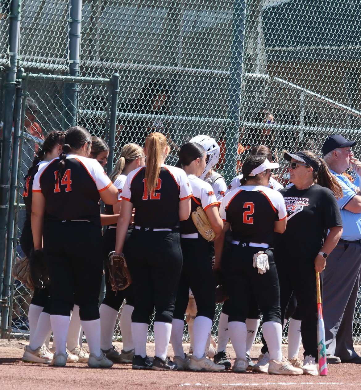 Head coach Heather Wood talks to the Tigers softball players before they go out onto the field. Wood said she has seen a lot of change in the team in her time as the head coach.