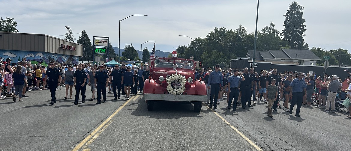 Fire responders and families make their way along Sherman Avenue on Friday.