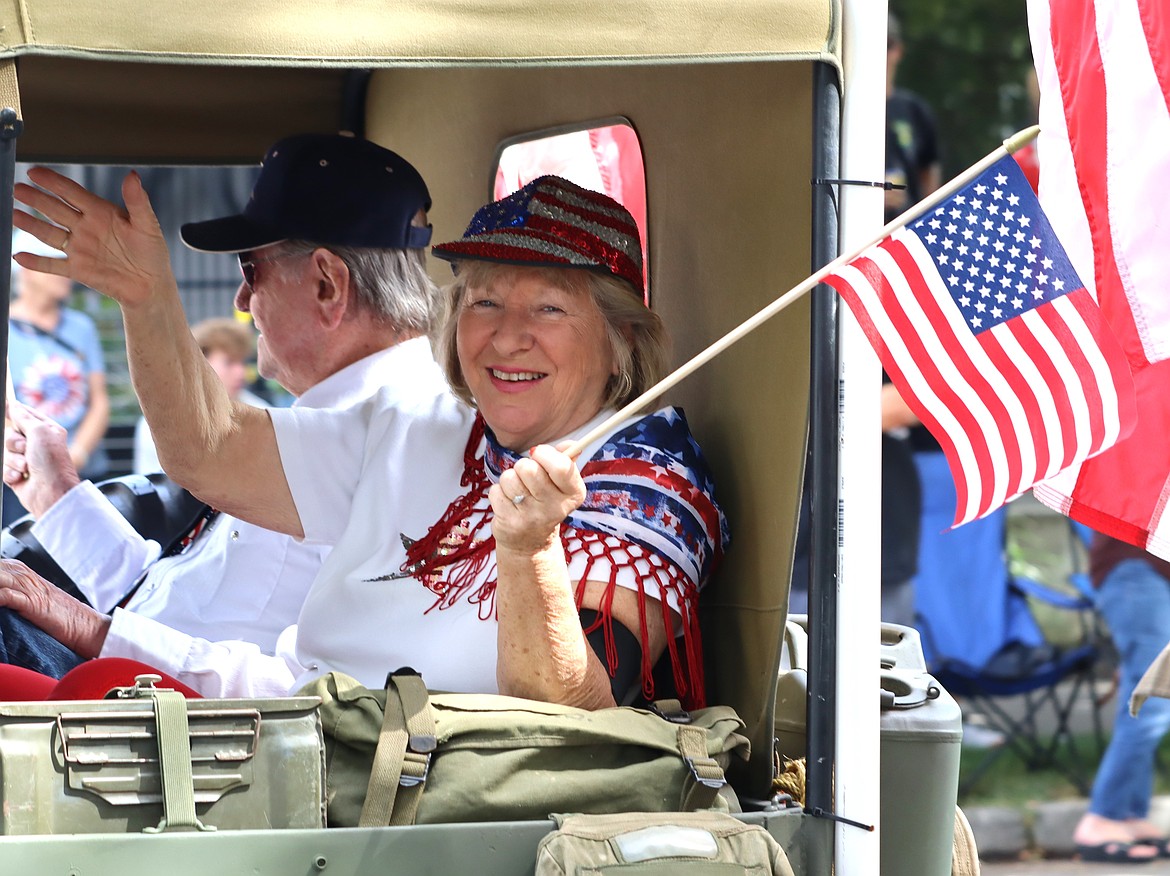 A woman smiles and waves in the parade.