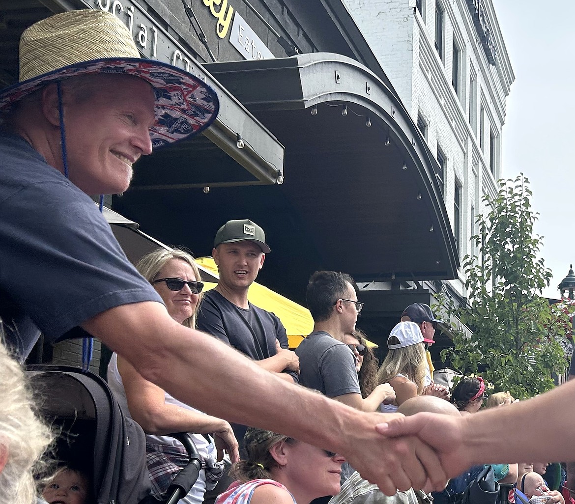 Veteran Dave Irving shakes hands with Coeur d'Alene High School football players during the Fourth of July parade.