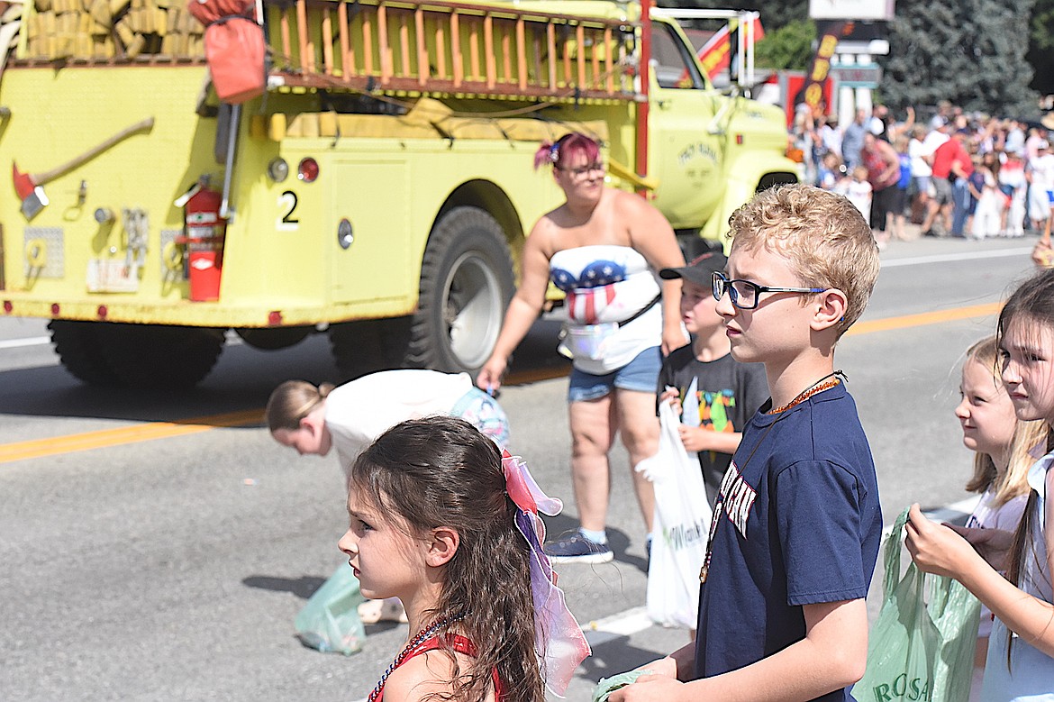 Youngsters wait patiently along U.S. 2 for candy to be thrown during Friday's 2025 Troy July 4 parade. (Scott Shindledecker/The Western News)