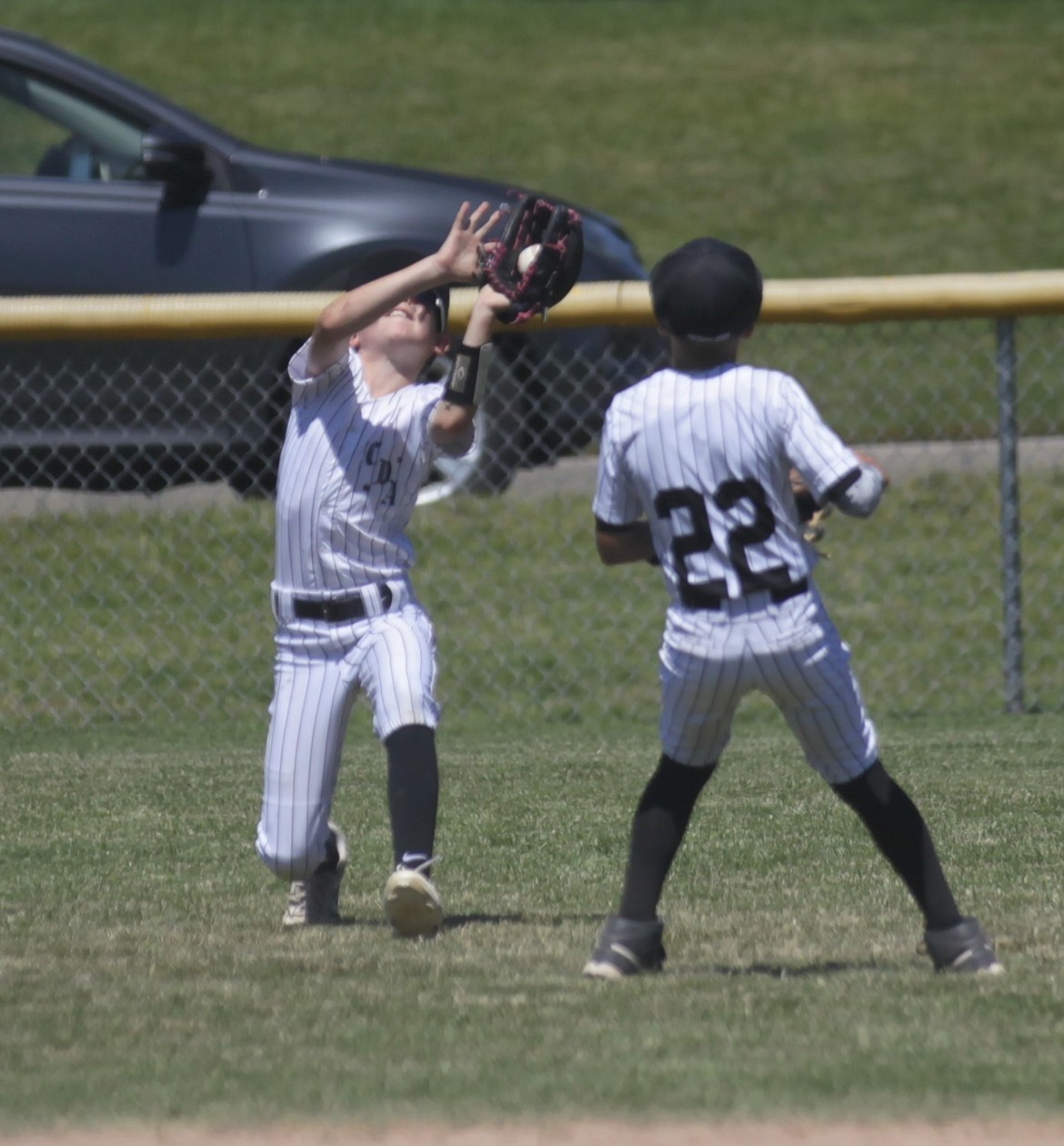 MARK NELKE/Press
Coeur d'Alene left fielder Hudson Whiteman makes a running catch as shortstop Westin Holmquist (22) closes in Saturday during the Idaho Little League District 1 baseball championship game Saturday at Canfield Sports Complex in Coeur d'Alene. Coeur d'Alene defeated Lewiston 5-0 to advance to the best-of-3 state playoffs next weekend in the Boise area against the District 2 champions.
