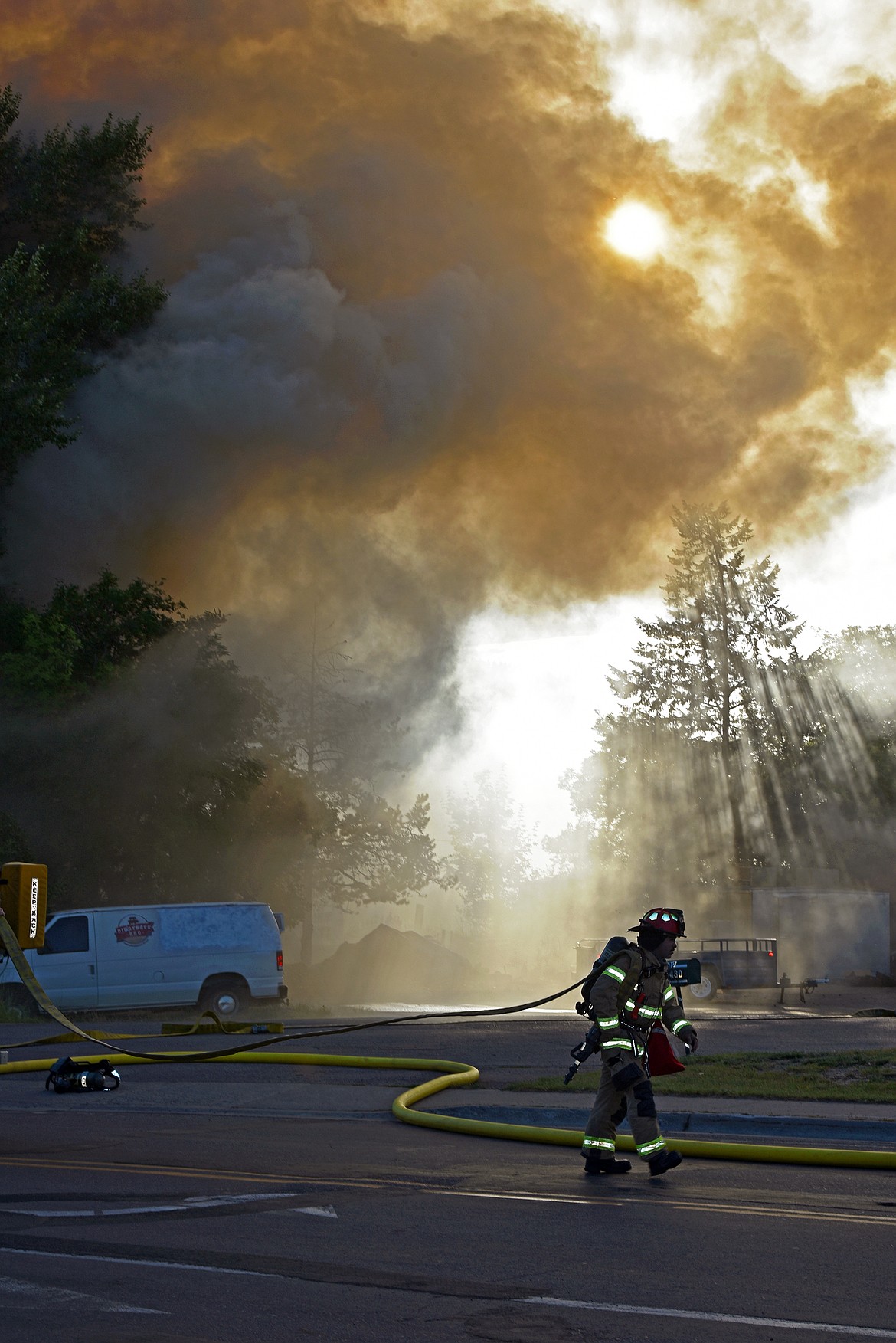As the sun sets on Sunday, July 13, first responders fight a fire in an abandoned building located at the north end of the viaduct in Whitefish. (Kelsey Evans/Whitefish Pilot)