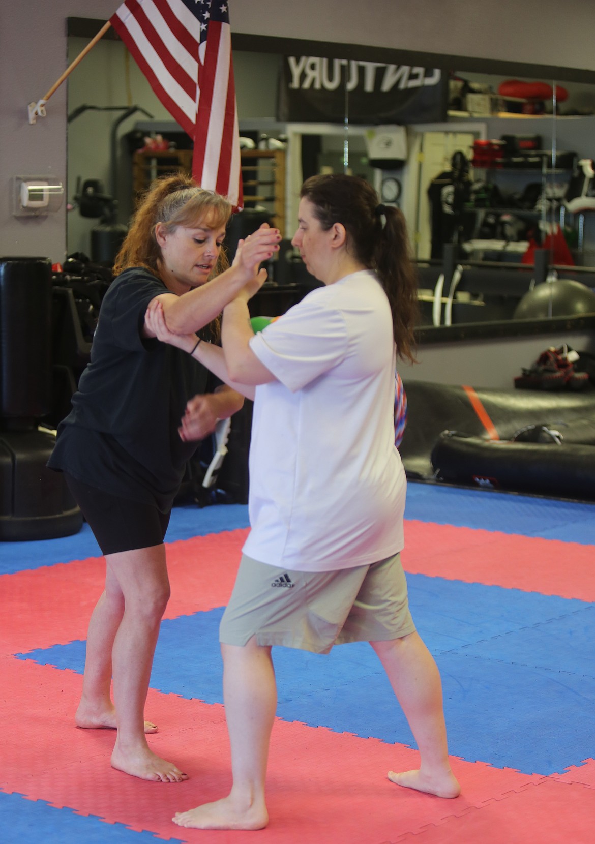 Brandi Guertin, left, guides a student, right, through a grappling movement during their Mat Monday seminar. Guertin said their hopes for the seminar were that anyone that attends has a positive takeaway, even if they do not sign up for classes.