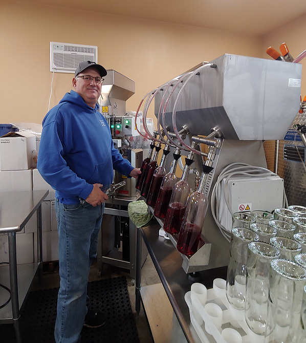 Jim Sheppard bottles wine on a six-place bottle filler in March 2022.