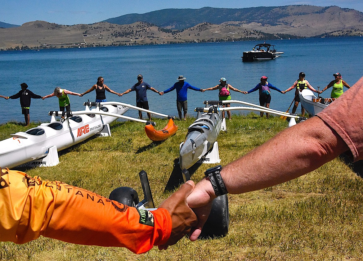 Paddlers hold hands and surround the canoes at the Big Arm Canoe Club after a 25-mile paddle from the Polson Fairgrounds. (Berl Tiskus/Leader)