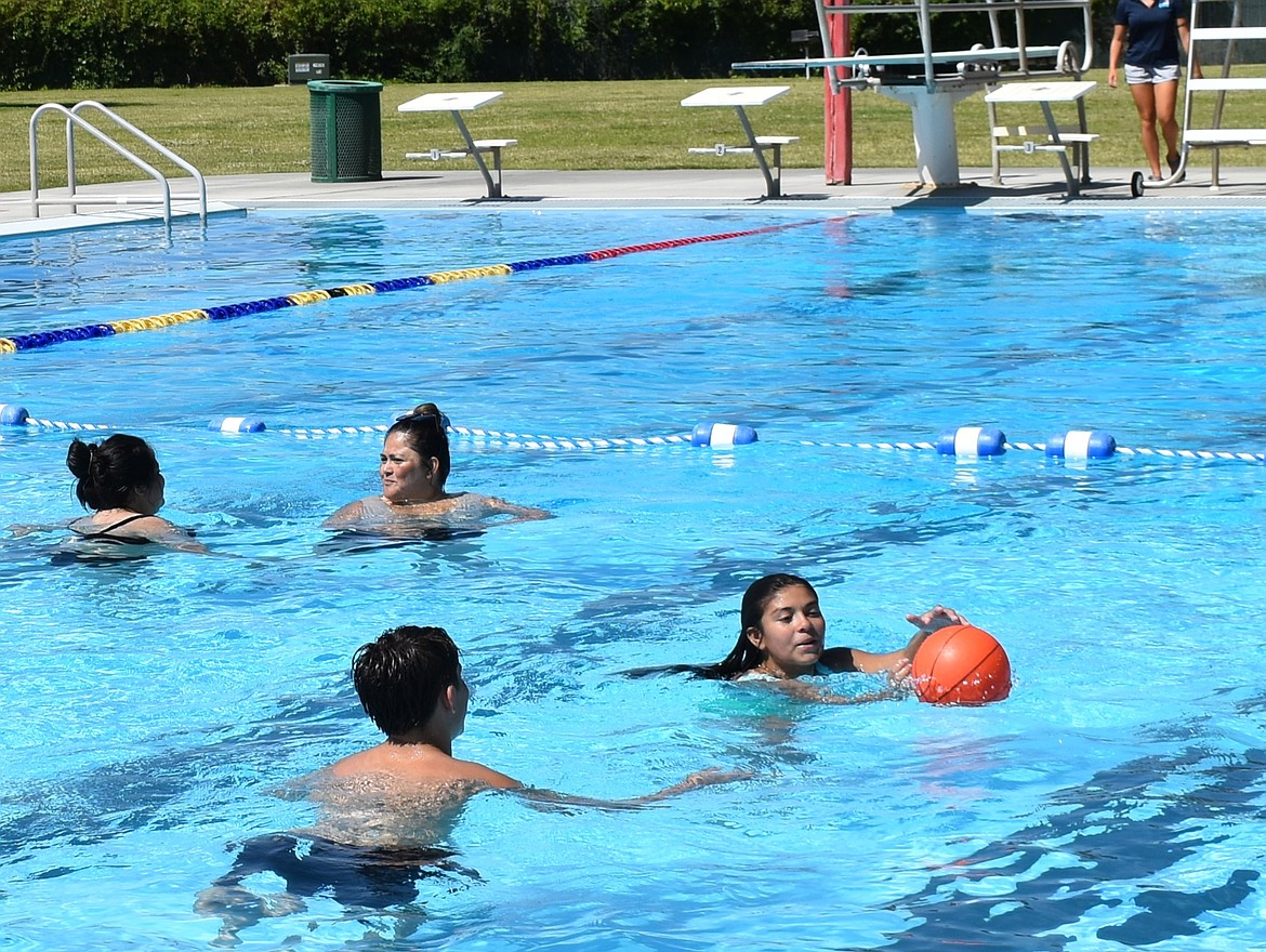 Two teens play with a basketball in one of the pools at Splash Zone water park. Ephrata Parks and Rec will be hosting a Doubles Beanbag Toss Tournament at the water park August 23 open to ages 13 and up.