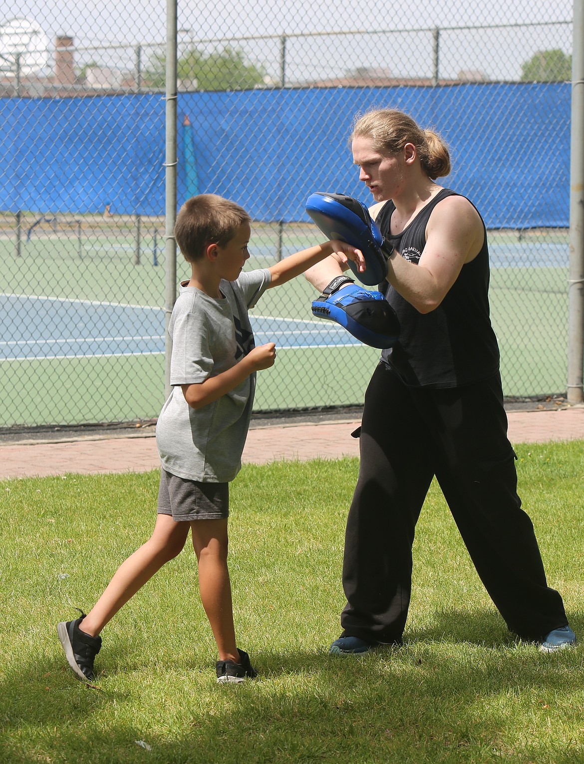Jacob Guertin helps a young student work through his striking combinations. Assistant instructor Brandi Guertin said learning martial arts can help build confidence in students.