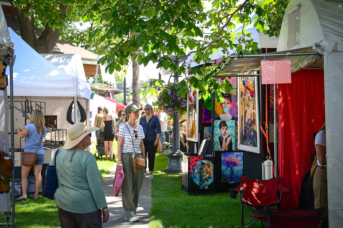 Visitors walk through a row of artists' booths at the Glacier Art Museum's 55th annual Arts in the Park festival at Depot Park in Kalispell on Friday, July 18. Kalispell's longest-running arts and music festival features a lineup of 80 juried artist booths, plein air painters, live music, food trucks and a beer and wine garden. (Casey Kreider/Daily Inter Lake)