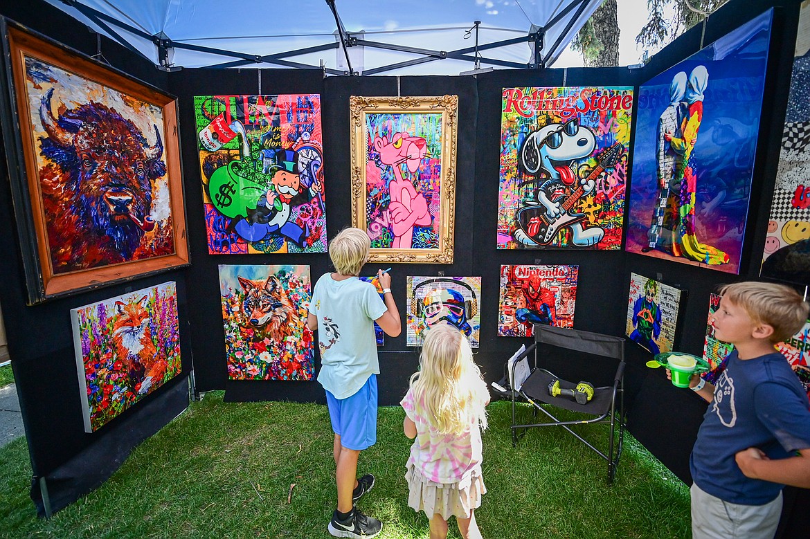 Visitors check out the oil and acrylic urban contemporary pieces of artist Oriana Gerez, owner of Gerez Gallery in Miami, Florida, at the Glacier Art Museum's 55th annual Arts in the Park festival in Depot Park in Kalispell on Friday, July 18. Kalispell's longest-running arts and music festival features a lineup of 80 juried artist booths, plein air painters, live music, food trucks and a beer and wine garden. (Casey Kreider/Daily Inter Lake)