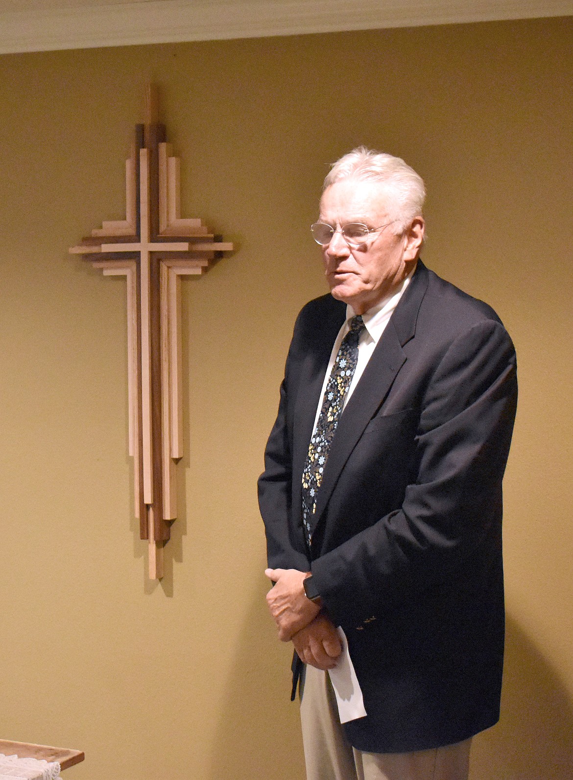 Reid Baker of the Church of Jesus Christ of Latter-day Saints speaks in front of the newly restored cross at the reconsecration of the chapel at Brookdale Hearthstone Assisted living Thursday.