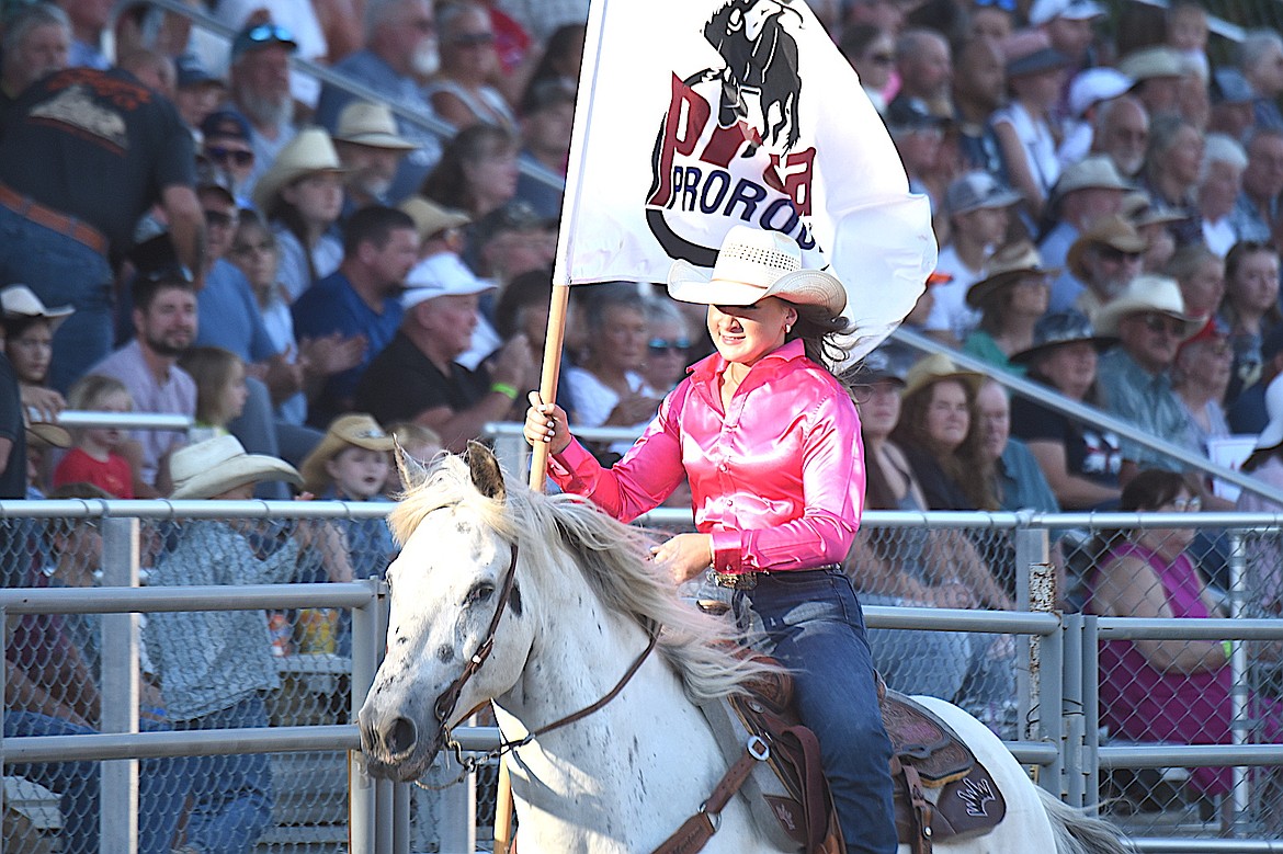 Ellie Bucher, right, carries the PRCA Rodeo flag Friday, July 25, 2025, at the Kootenai River Stampede in Libby. (Scott Shindledecker/The Western News)