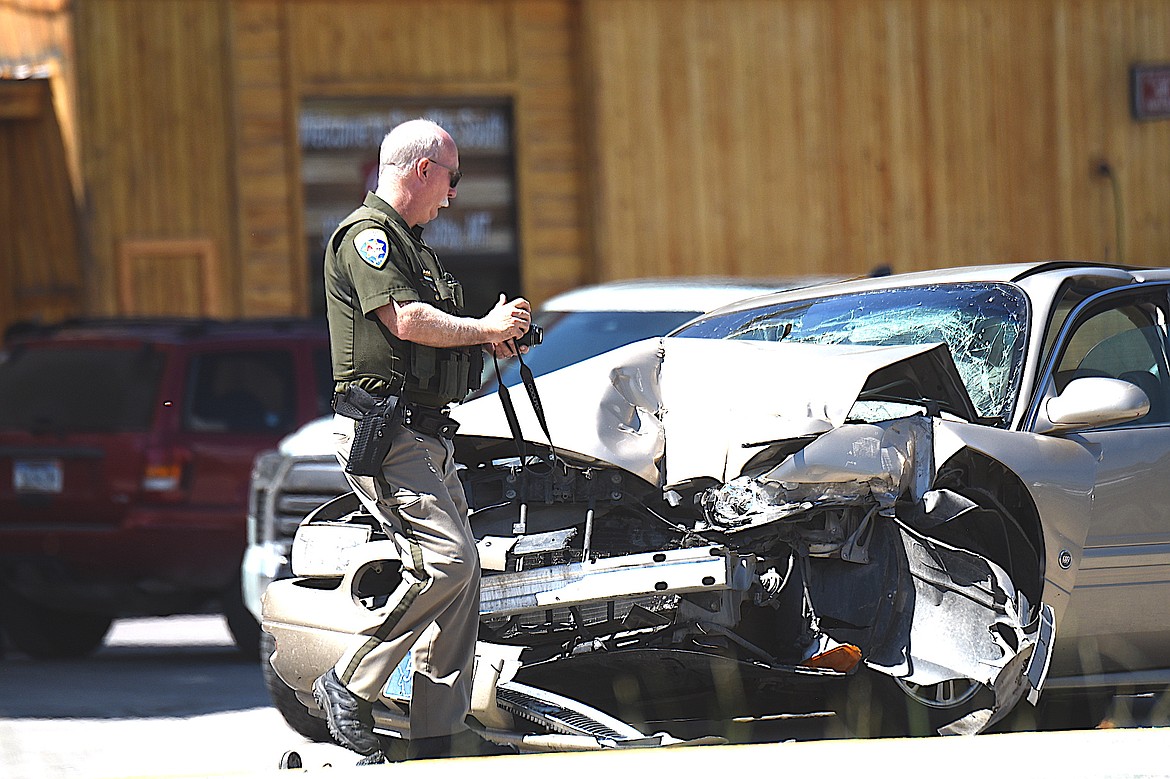 Montana Highway Patrol Trooper Bryce Ford takes photographs at an accident scene Tuesday, July 29, 2025, in front of Saverite South in Libby. (Scott Shindledecker/The Western News)