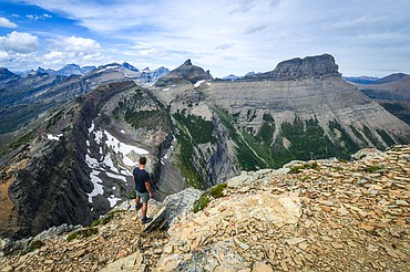 Jackson Slabaugh, from Akron, Ohio, checks out the view north along the Continental Divide, with Mount Wilbur, right, and Iceberg Peak, center, from Swiftcurrent Lookout in Glacier National Park on Monday, July 28. (Casey Kreider/Daily Inter Lake)