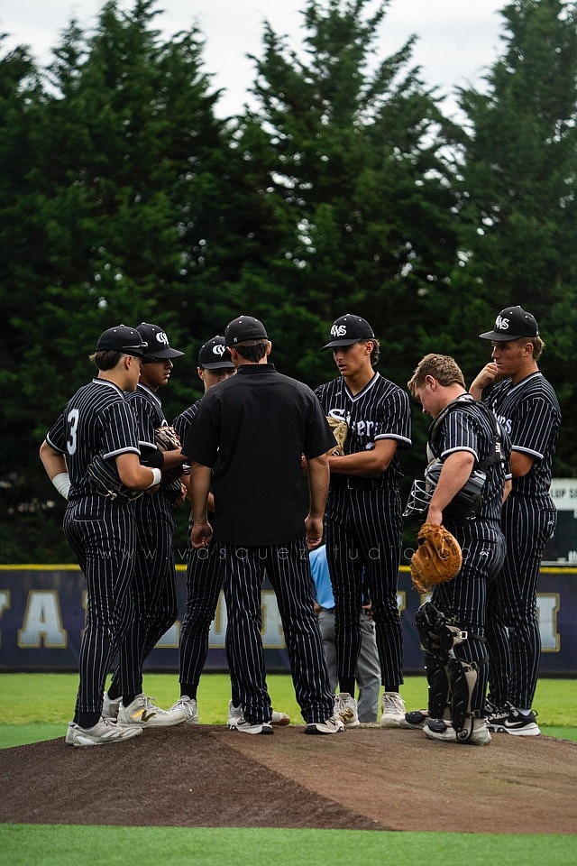 Sixers players gather around coach Trey Evans on the mound during one of the games at the 16U Invitational Tournament. Evans said he is proud of the 16U team and the entire Sixers organization for their success during the summer season.