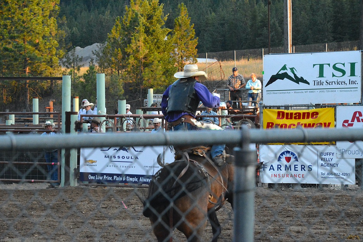 A saddle bronc rider tries to make it to eight seconds in front of the sold-out crowd during Saturday night's rodeo in Superior. (Mineral Independent/Amy Quinlivan)