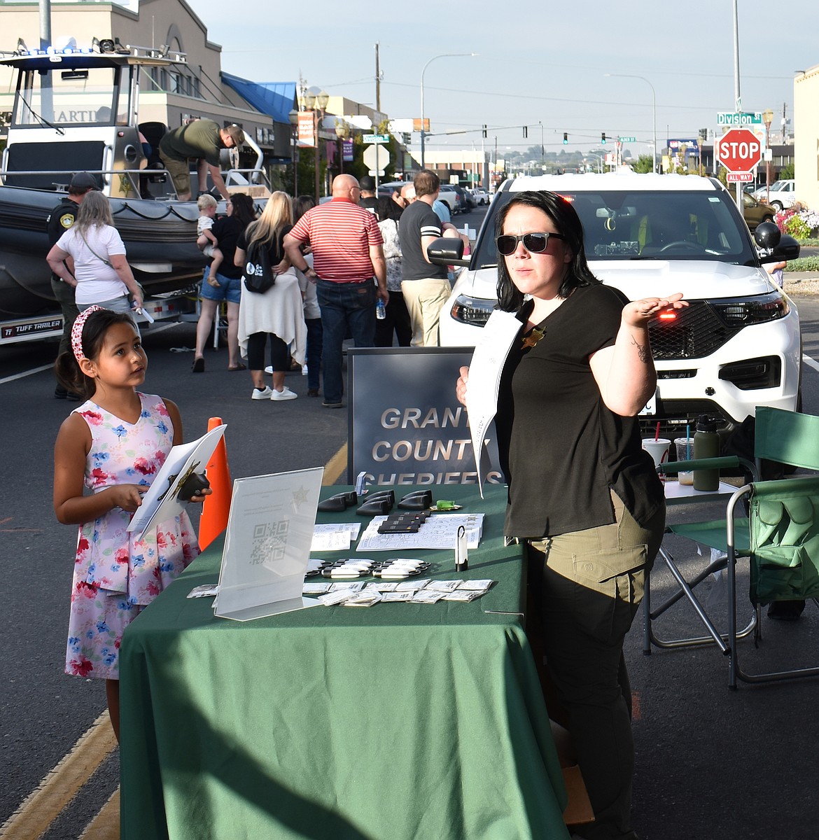 GCSO Emergency Management Specialist Jessica Olson, right, tells 7-year-old Sally Ortega about the Mobile Command Center at National Night Out in Moses Lake Tuesday.