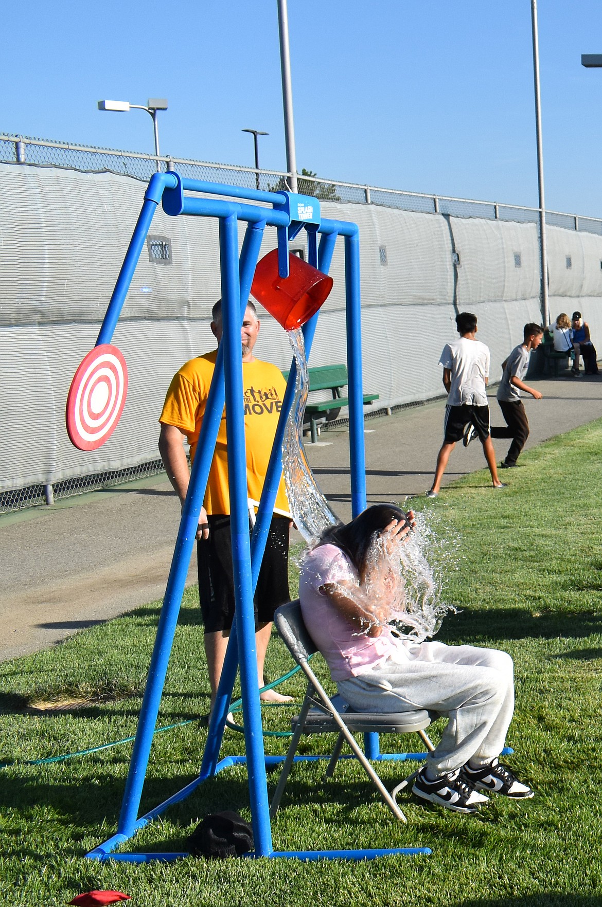 A young attendee at Quincy’s National Night Out suffers the consequences of a well-placed pitch to the dunk tower Monday.