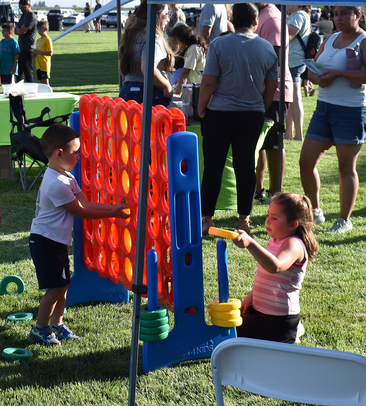 Liam Valle, 4, left, and his sister Delilah Valle, 6, play a game of Connect Four at National Night Out in Quincy.