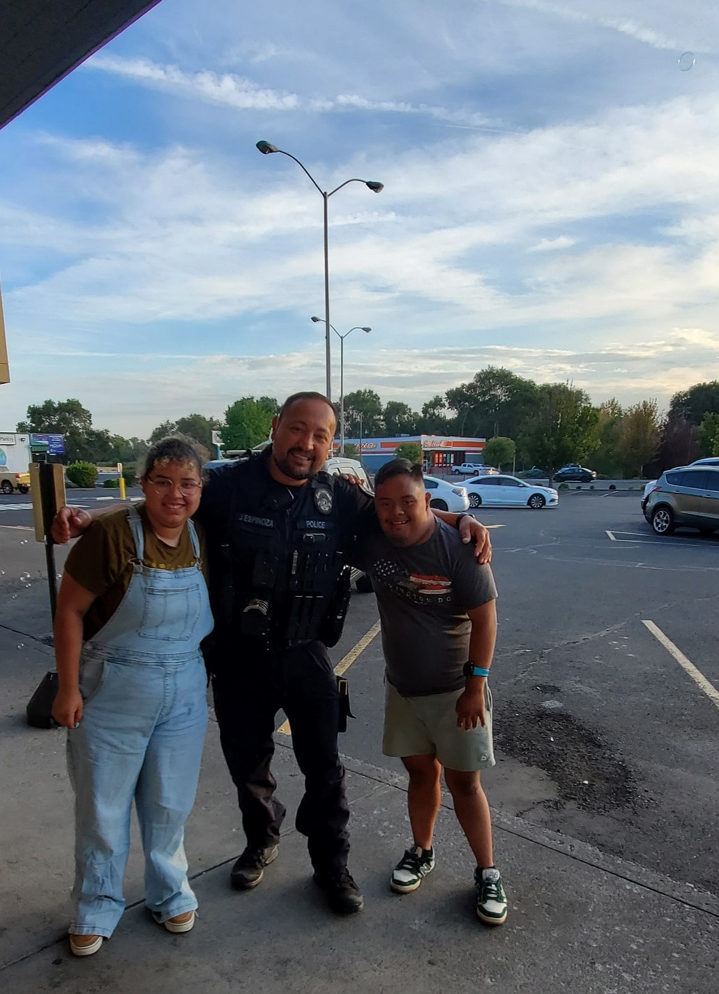 Josline Dominguez-Gomez and Eric Ocampo stand on either side of SRO Joaquin Espinoza during the fundraiser. Assistant coach Sarah White said they received a lot of community support from those who attended National Night Out.