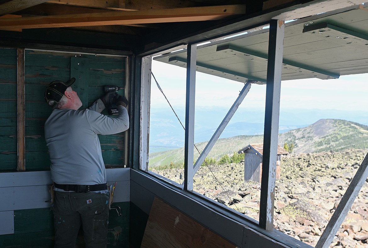 Chuck Stearns winterizes Northwest Peak Lookout on July 26, 2025. (Hailey Smalley/Daily Inter Lake)