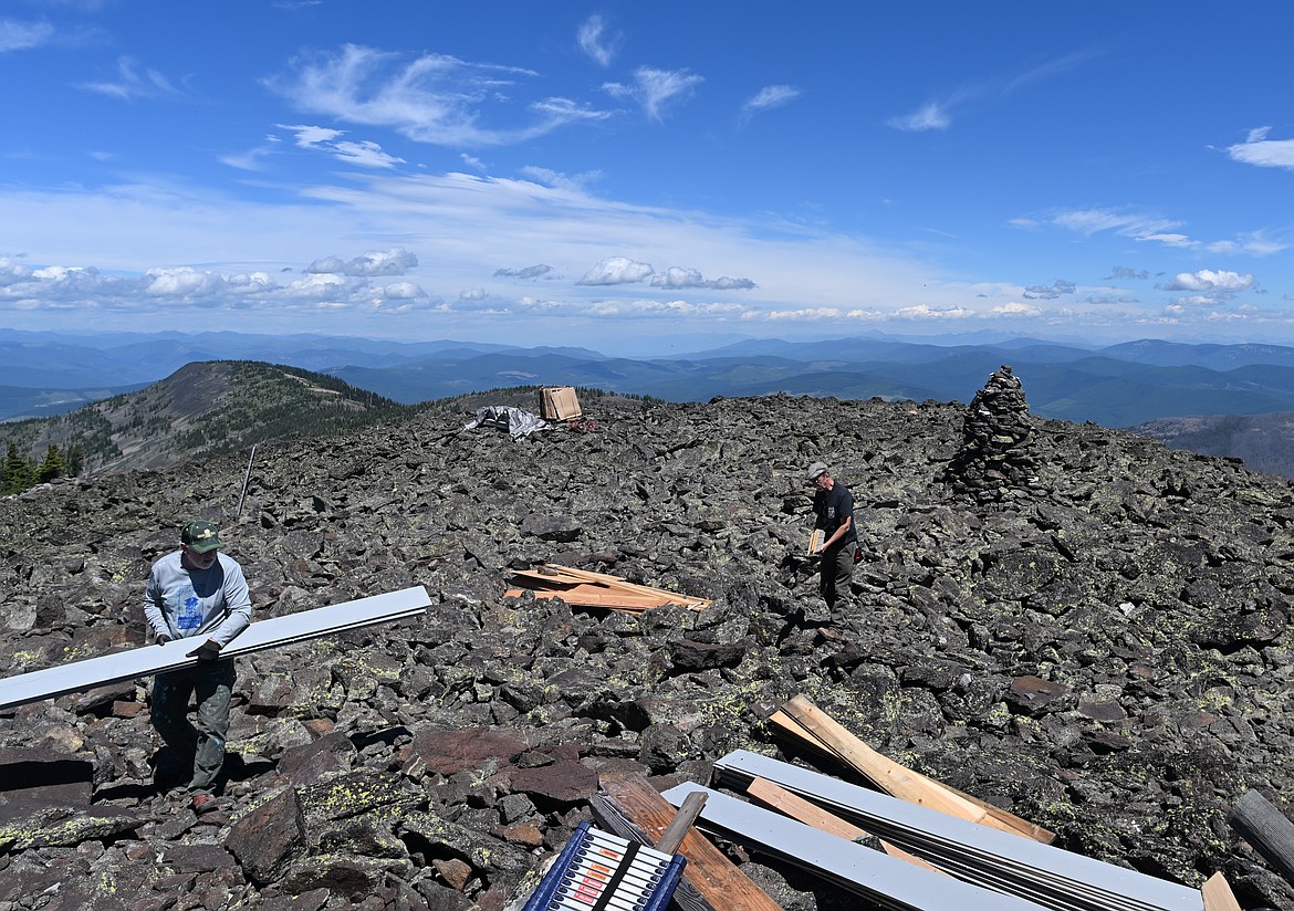 Volunteers from the Montana Northwest Lookout Association carry lumber from the site where it was dropped via helicopter near Northwest Peak Lookout. (Hailey Smalley/Daily Inter Lake)