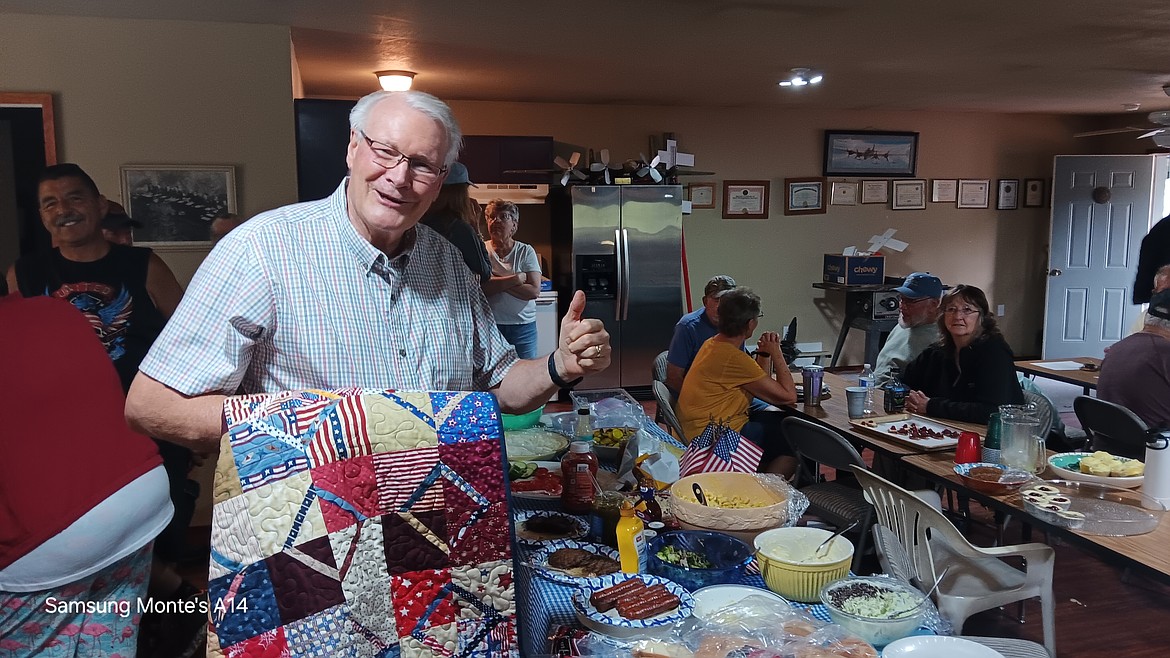 Air Force veteran Bruce McClelland took his quilt with him through the potluck chow line on Monday evening. (Monte Turner/Mineral Independent)