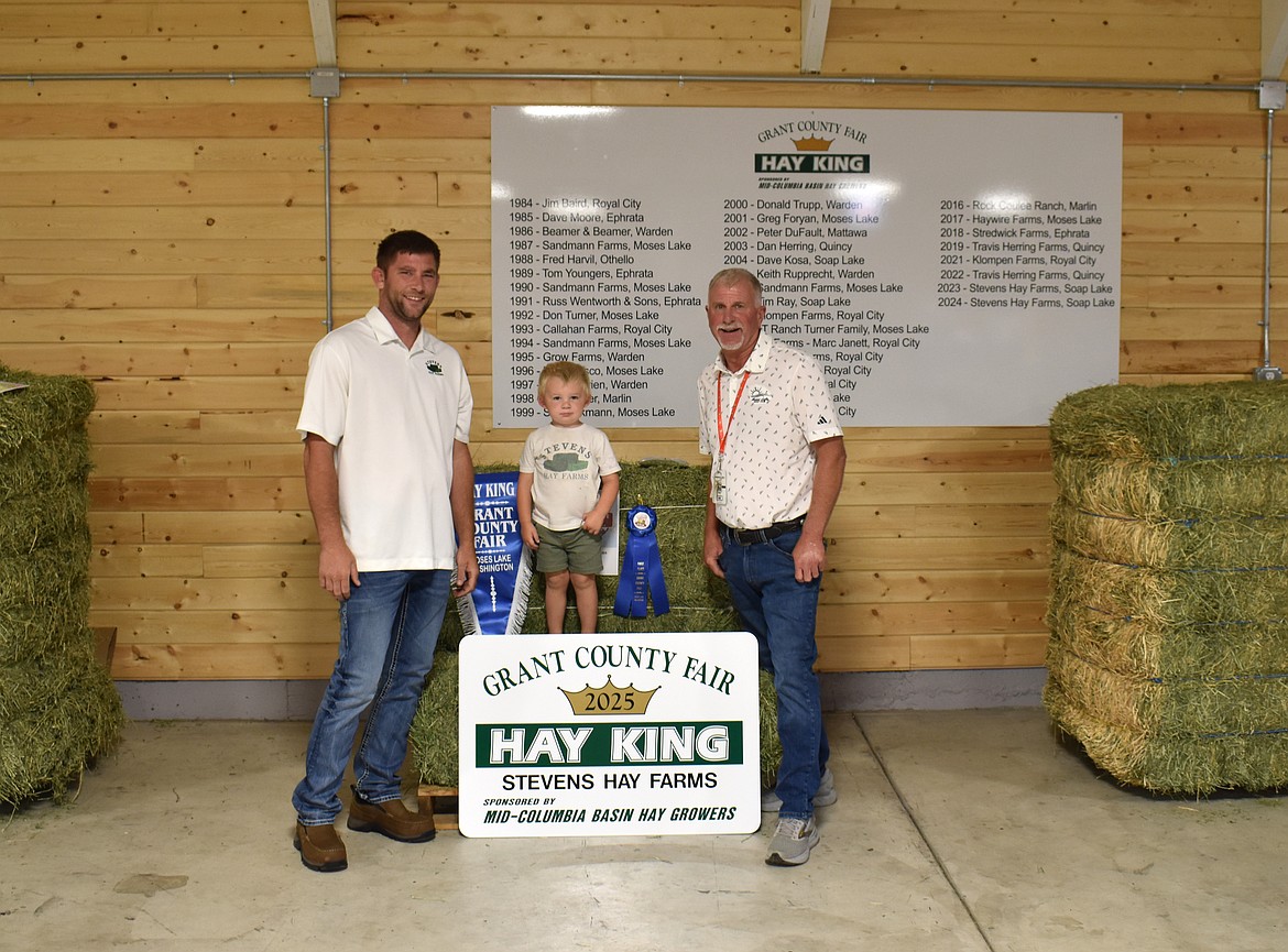 MOSES LAKE – Stevens Hay was named Hay King for the third year in a row Tuesday, the first grower to achieve that distinction. From left: Stevens hay co-owner Kye Stevens, 3-year-old Hudson Stevens and contest superintendent Kirk Jungers. Look for the full story in the August edition of the Basin Business Journal.
