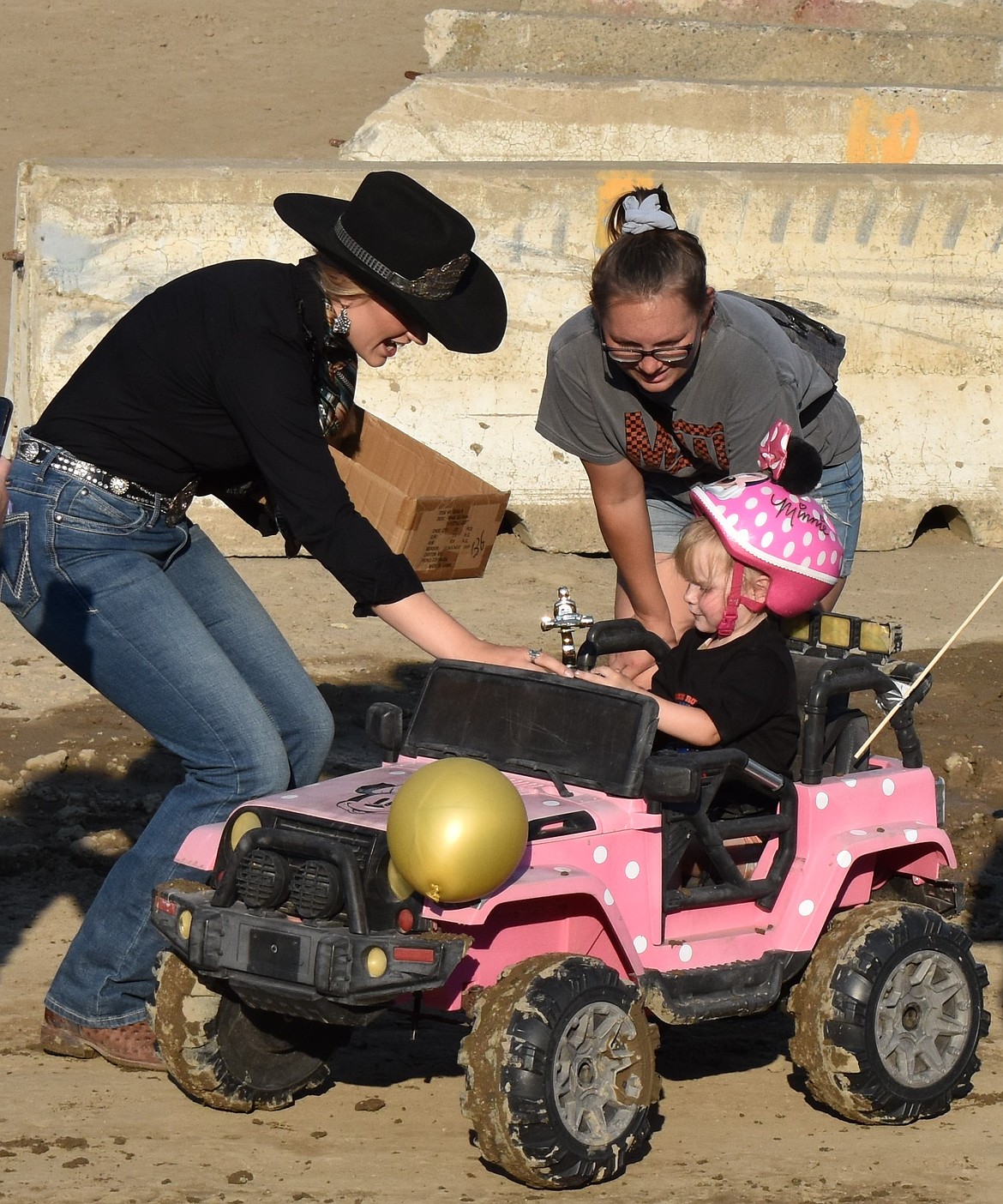 A young girl in her Minnie Mouse-themed Power Wheels receives a trophy from Miss Coulee City Last Stand Rodeo Eryne Anderson after the Youth Power Wheels Demo concluded.