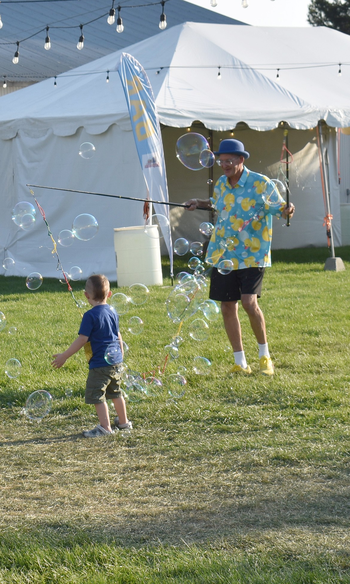 The Bubbler fascinates a young visitor to the Grant County Fair with orbs of rainbowy light.
