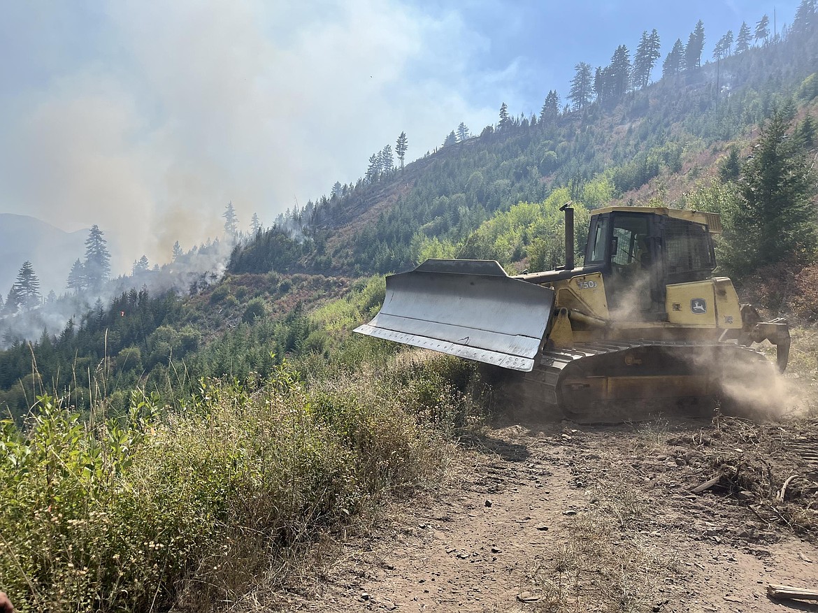 A bulldozer cuts a fireline to help contain the Knowles Fire in Sanders County on Aug. 22, 2025. Crews are using ground equipment to reinforce control lines and improve access in steep, forested areas. (Inciweb photo)