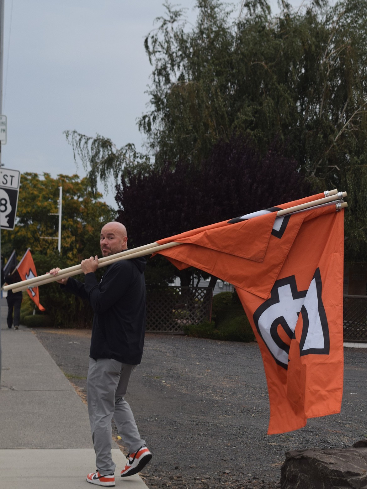 Superintendent Ken Murray helps put up flags on Basin Street on the first day of school at Ephrata School District.