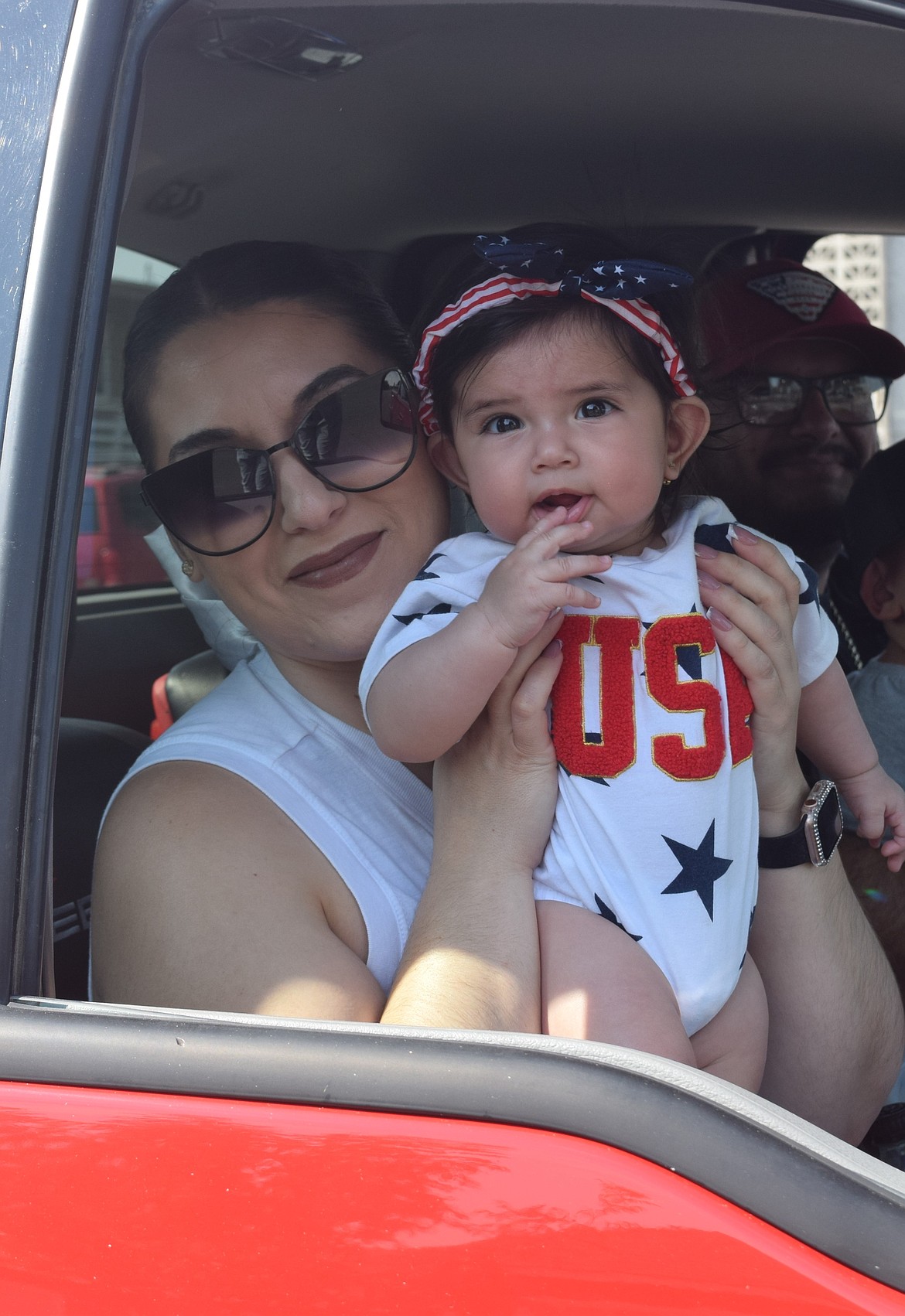 Two Warden Community Days parade participants smile through their truck window Monday.