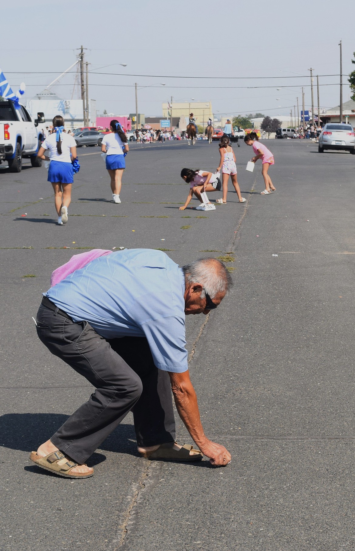 Warden residents, both younger and older, collect candy off Main Street on Monday.