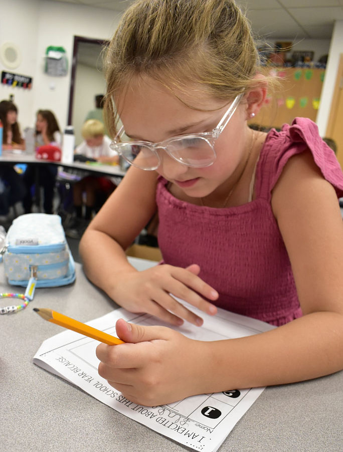 Betty Kiefer Elementary fourth grader Blake Gorton works on her "I am excited about this school year because…" worksheet Tuesday during the first day of school.