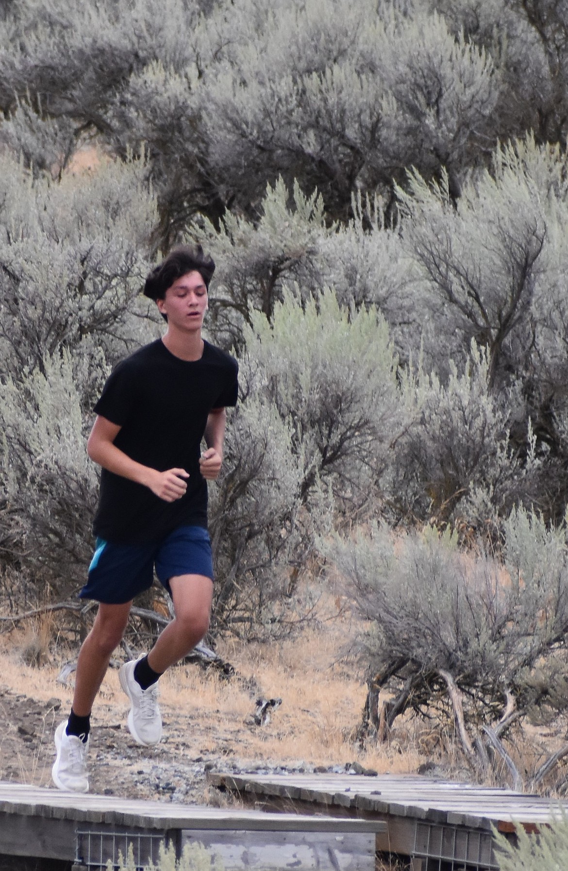 Tigers’ Isaac Avila makes his way over a small bridge at the Beezley Hills hiking trail. Coach Lyndsey Roberts said the team consists of a large number of experienced returners.