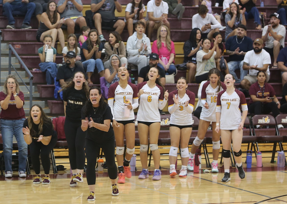 The Mavericks bench and coaching staff celebrate after they scored a point against Hermiston Saturday. The Mavs only dropped the first set before winning three straight to win 3-1.