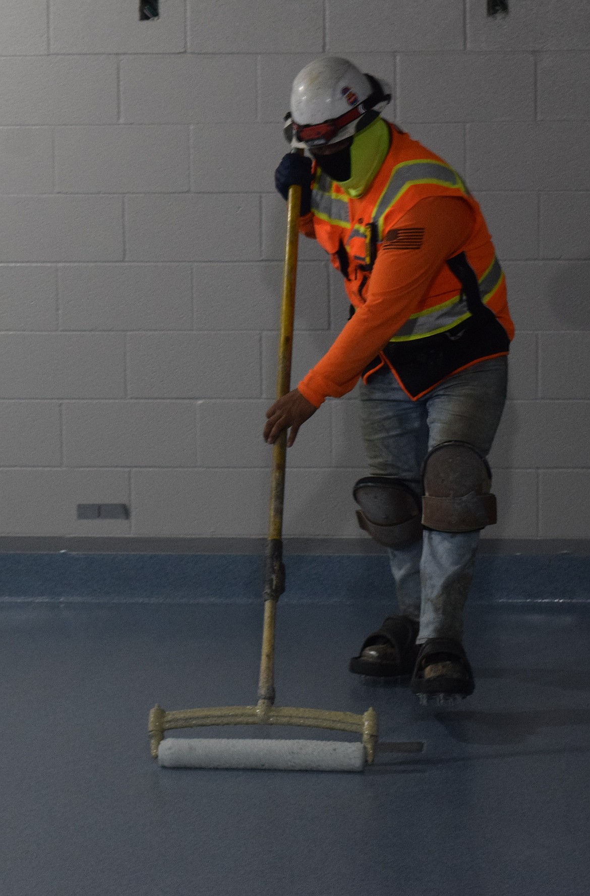 A worker paints the floors in the break room for staff at the new Grant County Jail.