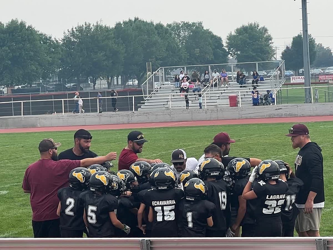 The coaching staff speaks with the Jr. Mavs fourth-grade team as they prepare to face off against the Jr. Huskies squad in Othello. The Mavs would go on to take a 25-0 victory.