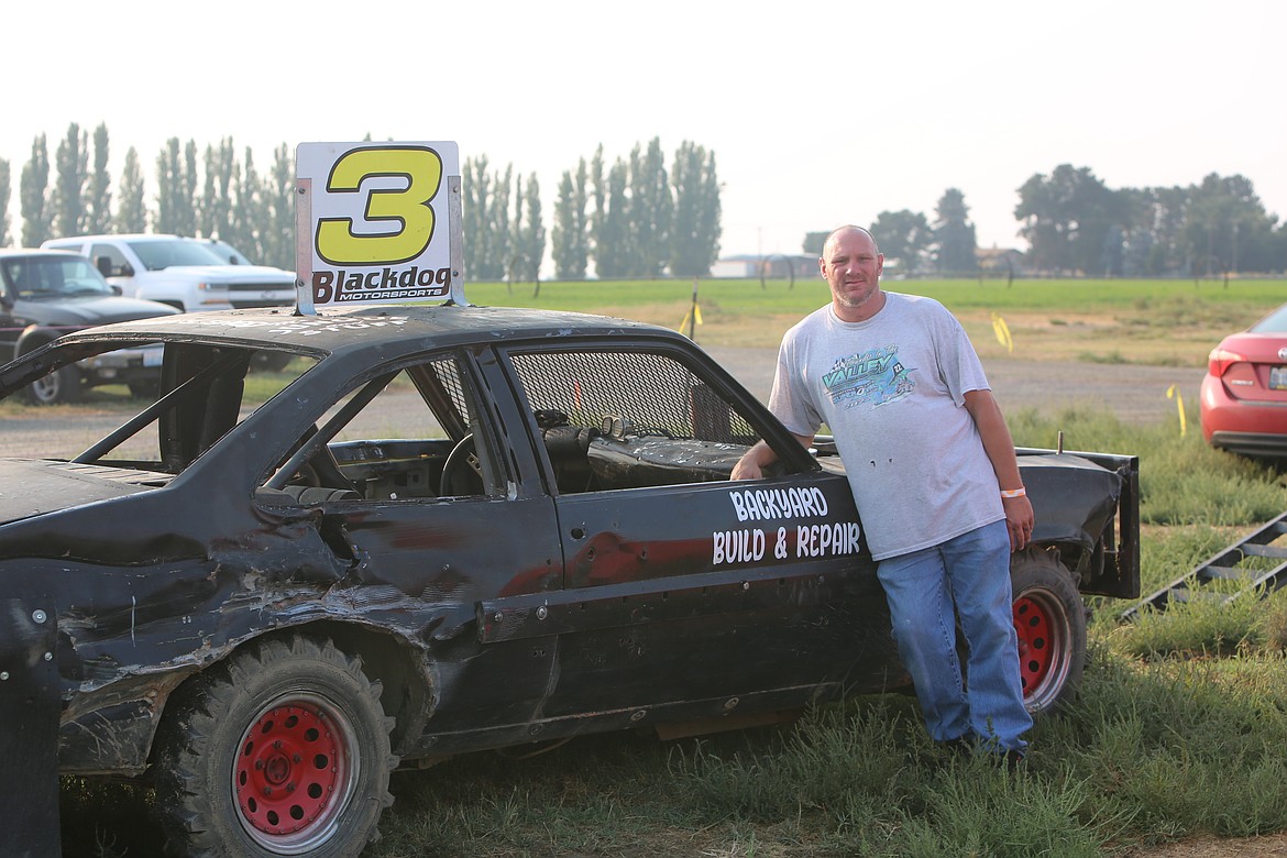 Chad Moore stands next to his Derby car ahead of the heat races at the Othello Demolition Derby. Moore said his brother lent him the car to ride for this year’s Derby competitions.