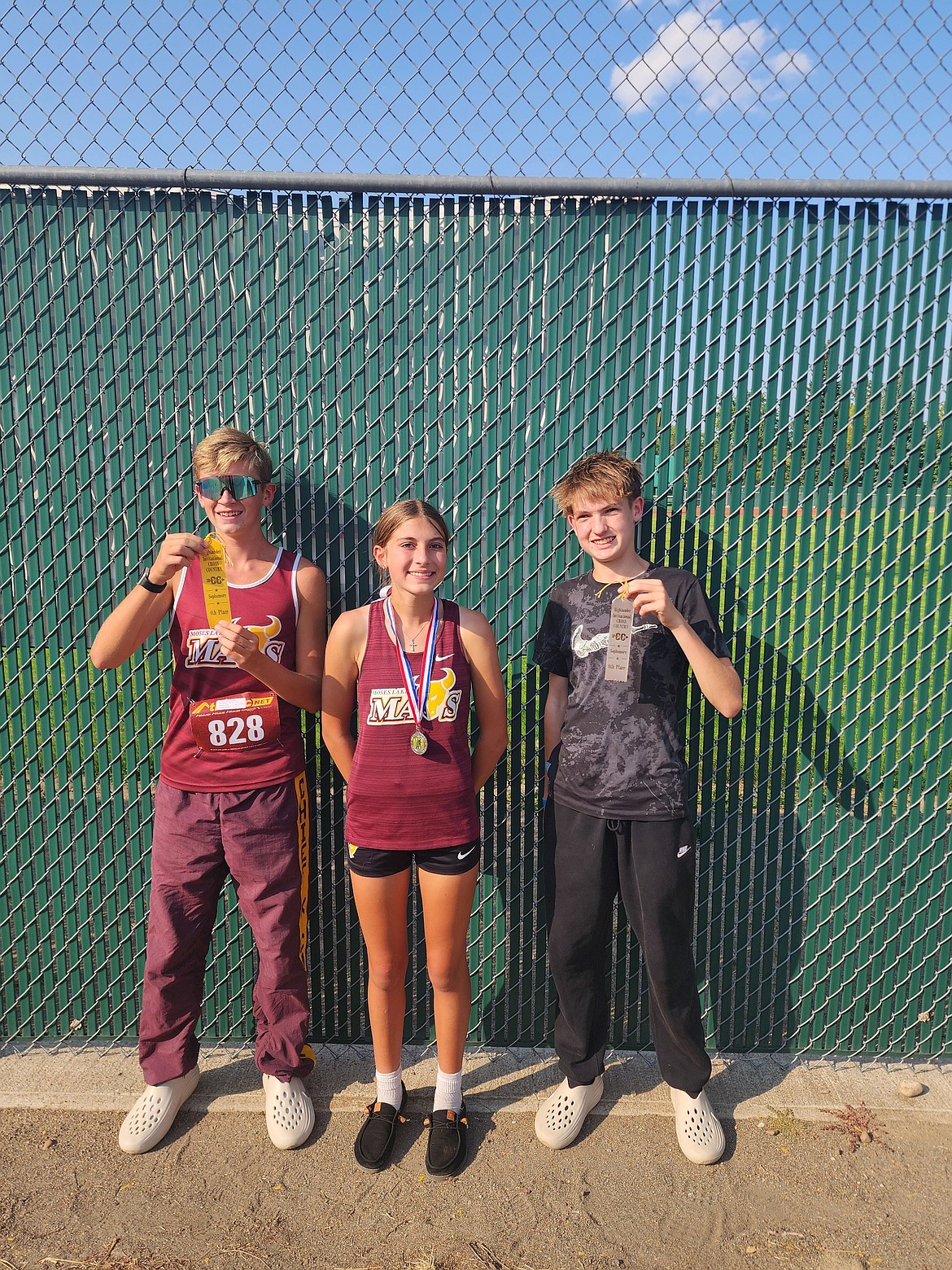 Mavs sophomore Lane Christensen, freshman Aspen Hoenes, and sophomore Maxwell Jolley show off their awards for their efforts at the Highlander Invitational. Hoenes made Mavs history breaking all-time record at the school by 30 seconds.