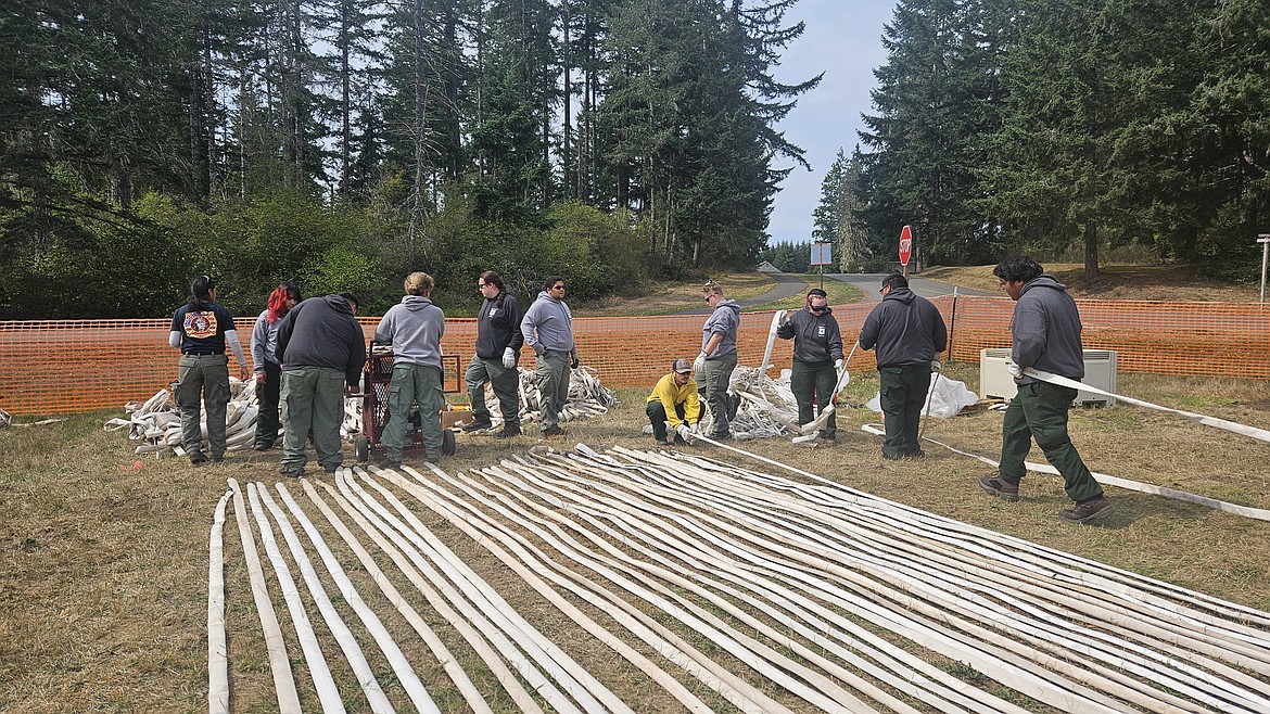 Job Corps students check and roll hoses for fire crews to use on a Washington wildfire.