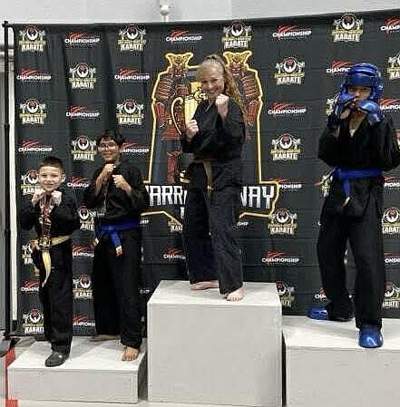From left: Freewind Martial Arts students Serjio Madrigales, Milan Bhatt, Brandi Guertin and Kelvin Bhatt stand on a podium after placing 10th in the Warriors War Cup tournament in Pullman. Freewind competed against 20 other schools.