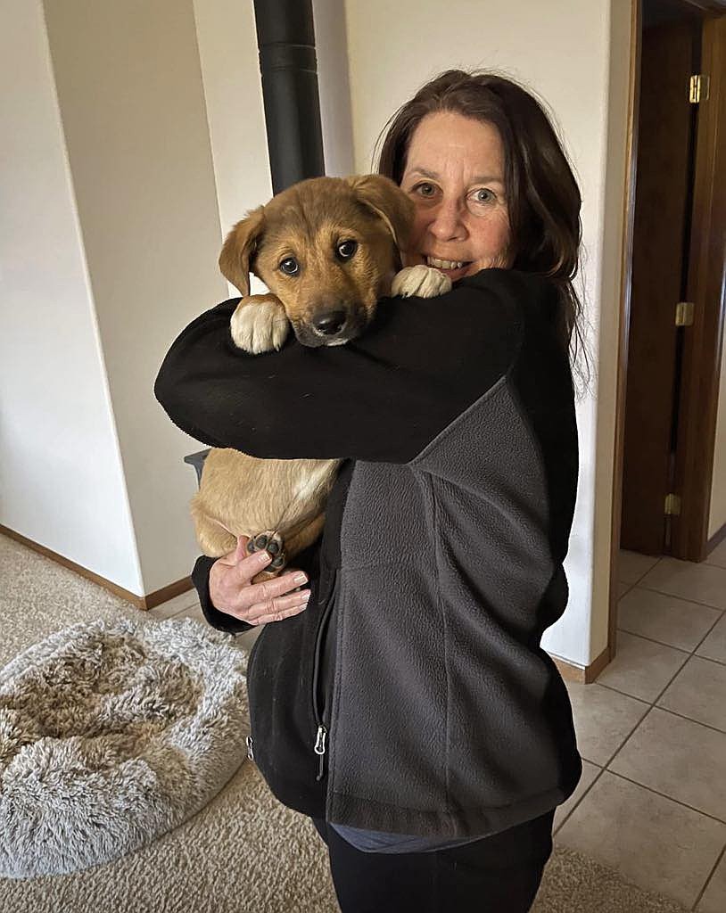The late Tracy Hill cuddles a dog rescued by Animal Rescue Friends Society of Grant County. Hill was one of the group’s founding members.